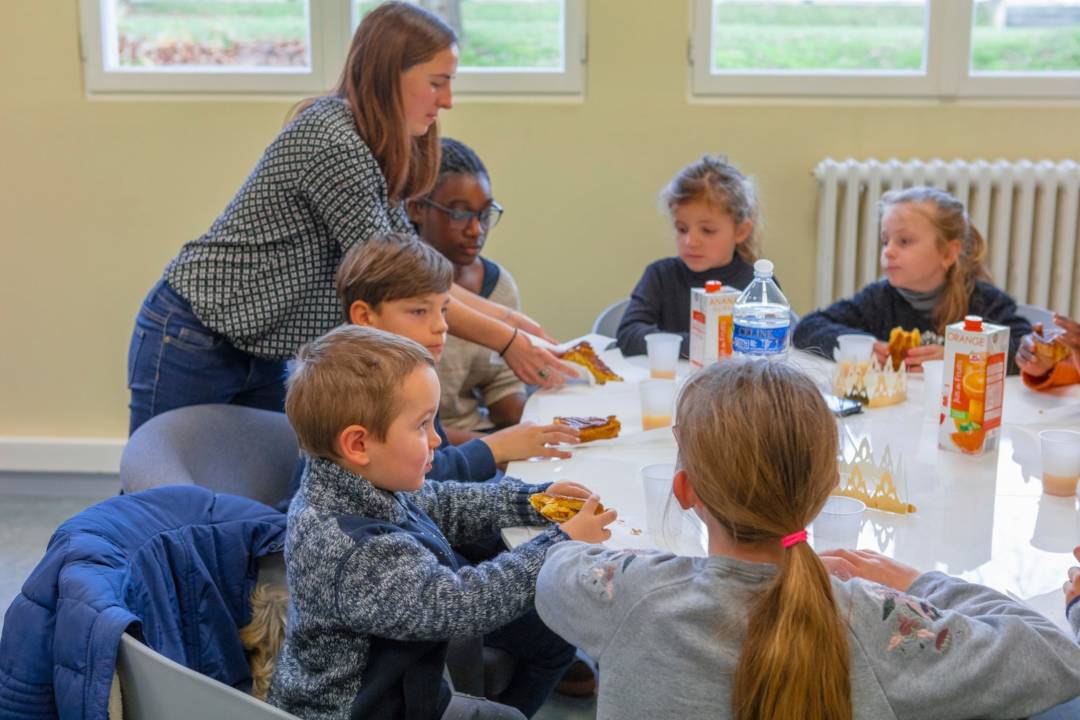  l'éducateur sert la galette des Rois aux enfants